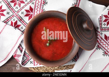 Tontopf mit ukrainischem Borsch und Rushnyk auf dem Tisch, Draufsicht Stockfoto