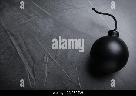 Kugelförmige Bombe mit brennender Sicherung auf schwarzem Hintergrund, Draufsicht. Platz für Text Stockfoto