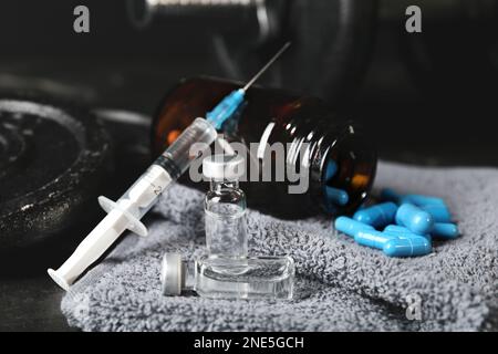 Verschiedene Drogen und Sportgeräte auf dem Tisch, Nahaufnahme. Dopingkontrolle Stockfoto