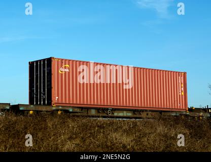 Globaler Schiffscontainer auf einem intermodalen Zug, Warwickshire, Großbritannien Stockfoto