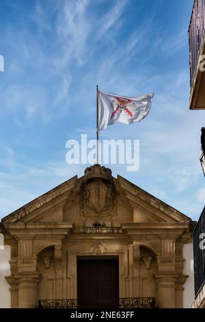 02-09-2023 ronda, malaga, spanien Fassade und Flagge am Eingang zur Stierkampfarena von Ronda über einem wolkigen blauen Himmel Stockfoto