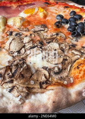 Pizza, Seitenblick lecker und wunderschöne typisch italienische Pizza mit Pilzen, Oliven und Speck in Italien. italienische Küche oder Hintergrund oder Oberfläche Stockfoto