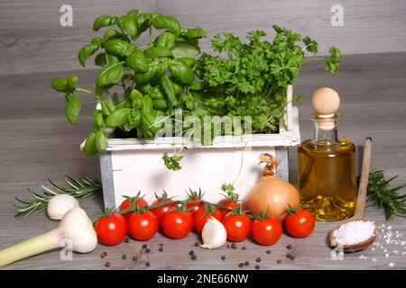 Verschiedene Kräuter und Gemüse, Glasflasche mit Olivenöl Stockfoto