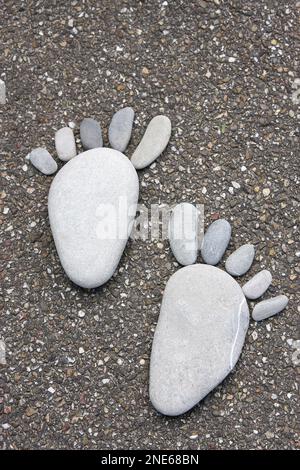 Steinfüße auf Asphalt Stockfoto
