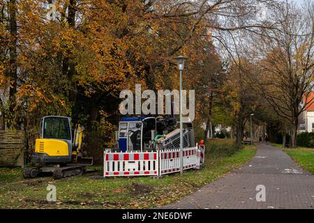 Bagger und Grabenbagger auf einer kleinen Baustelle neben dem Wanderweg im Park. Stockfoto