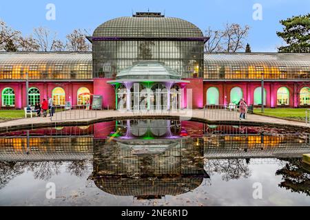 Frankfurt, Deutschland - 28. Dezember 2022: Farbenfrohes Licht an der Fassade des historischen Palmengartens Eingangsgebäudes bei der Lichtshow wintergarten 2022 - engl: WIN Stockfoto