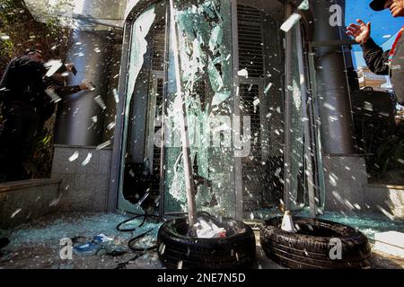 Beirut, Libanon. 16. Februar 2023. Libanesische Demonstranten zerstören den Eingang einer lokalen Bank in Beirut. Dutzende Libanesen griffen am Donnerstag mehrere Banken in der Hauptstadt Beirut an, inmitten der Wut über eine Wirtschaftskrise und eine weitere Abwertung der lokalen Währung gegenüber dem Dollar. Kredit: Marwan Naamani/dpa/Alamy Live News Stockfoto