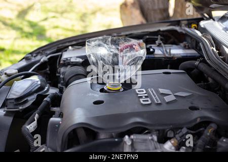 Ölwechsel in einem Mitsubishi-Automotor durch einen selbstgemachten Trichter. Russland, Anapa-25.04.2022 Stockfoto