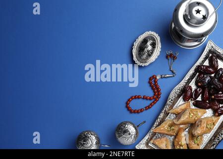 Flache Laienzusammensetzung mit arabischer Laterne und Snacks auf blauem Hintergrund. Platz für Text Stockfoto