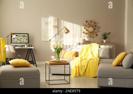 Stilvolles Wohnzimmer mit Sofa. Innendesign in Grau und Gelb Stockfoto