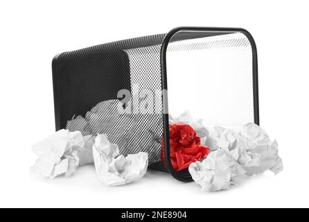 Korb mit verstreuten, zerknitterten Papierkugeln auf weißem Hintergrund Stockfoto