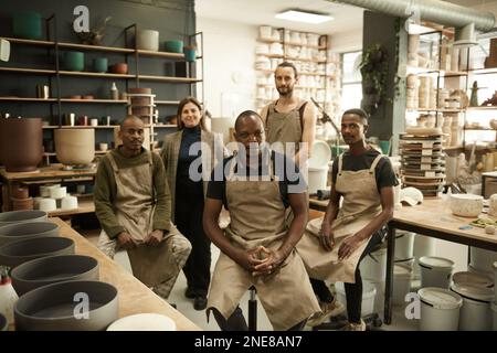 Eine Gruppe verschiedener Keramiker, die in einem Töpferstudio arbeiten Stockfoto