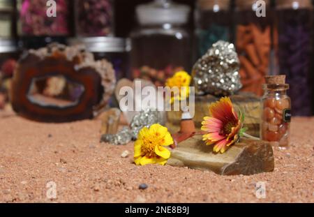 Gelbe Blumen mit Pyritfelsen und Kristallen auf dem australischen roten Sand Stockfoto