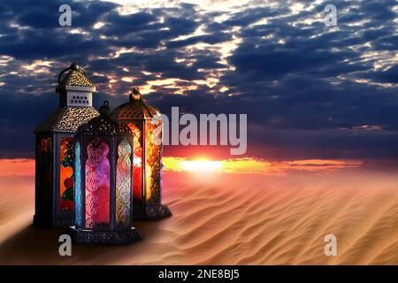 Wunderschöne arabische Laternen auf Sand bei Sonnenuntergang, Platz für Text Stockfoto