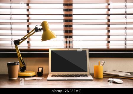 Moderner Laptop auf Holztisch im Innenbereich. Komfortabler Arbeitsplatz Stockfoto