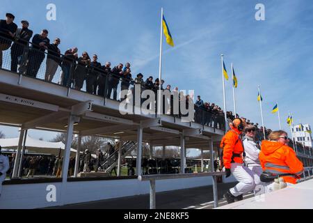 Zuschauer stehen auf dem Dach der Pit Lane und Marshals sitzen auf der Pit Lane Wall, 79. Mitgliederversammlung, Goodwood Motor Racing Circuit, Großbritannien Stockfoto