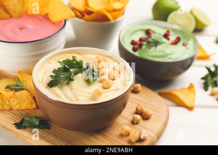 Schüssel mit köstlichem klassischem Hummus mit Petersilie auf weißem Holztisch. Platz für Text Stockfoto