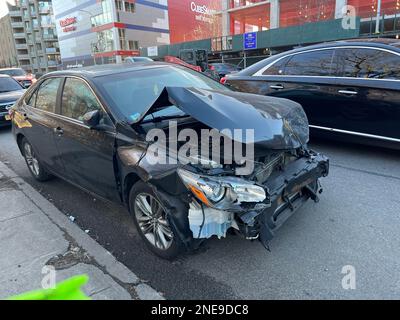 Beschädigte Vorderseite eines Autos, das auf der Straße geparkt ist, nach einem Unfall in Brooklyn, New York. Stockfoto