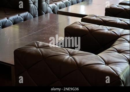 Blick auf das Sofamaterial aus Leder in eleganter brauner Farbe, Sofa bedeckt mit diamantförmigen Stücken, Nahaufnahme. Stockfoto