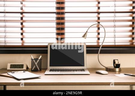 Moderner Laptop auf Holztisch im Innenbereich. Komfortabler Arbeitsplatz Stockfoto