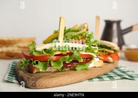 Köstliche Sandwiches mit Gemüse und Käse auf weißem Tisch, Nahaufnahme Stockfoto