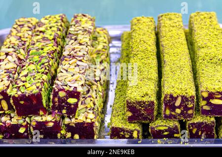 Orientalische Süßigkeiten. Traditionelle türkische Köstlichkeiten (Rahat Lokum) aus der Nähe. Türkischer Genuss mit Nüssen und Spänen. Selektiver Fokus Draufsicht. Stockfoto