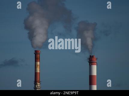 Zwei industrielle Schornsteine und Rauch am Himmel 17.02.2023 Bialystok Polen. Blick auf farbenfrohe Rauchschornsteine im Winter. Stockfoto