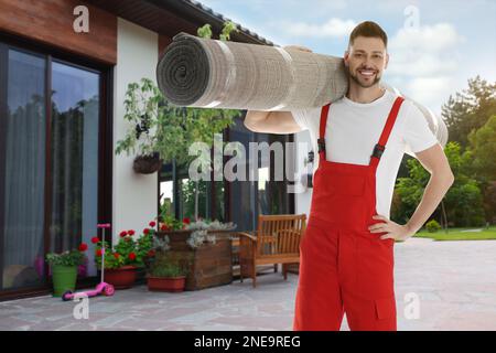 Arbeiter mit Rollteppich im Freien an sonnigen Tagen Stockfoto