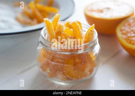 Kandierte Orangenstäbchen in Zucker, serviert in einem Glas. Stockfoto