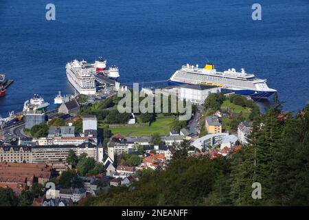 Blick auf Kreuzfahrtschiffe und Fischerboote im Hafen, Haakon's Hall und die Festung Bergenhus. Blick vom Gipfel des Berges Fløyen, Bergen, Norwegen. Stockfoto