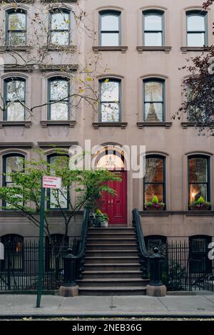 New York, USA - 21. November 2022: Fassade eines traditionellen Hauses mit einer treppe in West Village, einer bezaubernden Gegend von Manhattan, berühmt für ihre Geschäfte und Stockfoto