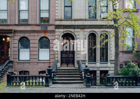 New York, USA - 21. November 2022: Außenansicht eines traditionellen Stadthauses mit einer treppe in West Village, einer bezaubernden Gegend von Manhattan, die für ihre Geschäfte berühmt ist Stockfoto