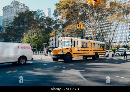 New York, USA - 22. November 2022: Gelber Schulbus auf einer Straße in Manhattan, New York. Die Stadt New York bietet Studenten kostenlosen Transport Stockfoto