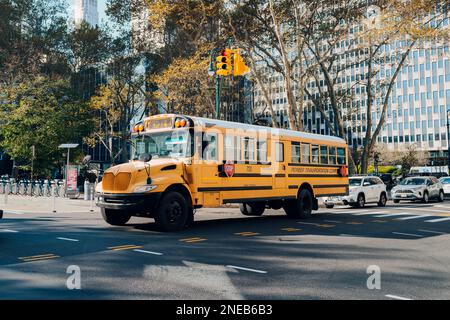 New York, USA - 22. November 2022: Gelber Schulbus auf einer Straße in Manhattan, New York. Die Stadt New York bietet Studenten kostenlosen Transport Stockfoto