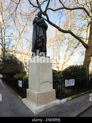 Statue von George Nathaniel Curzon, Carlton House Terrace, London, mit dem Garten des Reform Club dahinter. 1931 von Sir Bertram Mackennal geformt Stockfoto