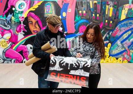 London, Großbritannien. 16. Februar 2023 Die Straßenkünstlerin Lady Pink signiert ein Autogramm für einen Besucher vor ihrer Graffiti Experience Installation, 2023, bei der Vorschau auf die Straße, Eine neue Ausstellung in der Saatchi-Galerie mit Werken von über 100 internationalen Künstlern, die als die umfassendste Graffiti- und Straßenkunstausstellung in Großbritannien bezeichnet werden. Die Show findet vom 17. Februar bis zum 9. Mai 2023 statt. Kredit: Stephen Chung / Alamy Live News Stockfoto