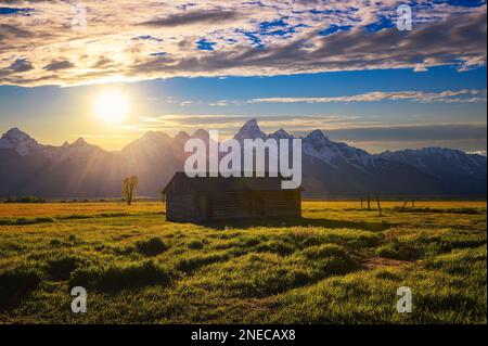 Sonnenuntergang über einem historischen Schuppen in der Mormon Row im Grand Teton National Park, Wyoming Stockfoto