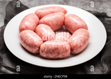 Gerolltes Botifarra, eine für Katalonien typische Schweinefleischwurst in einem weißen Gericht Stockfoto