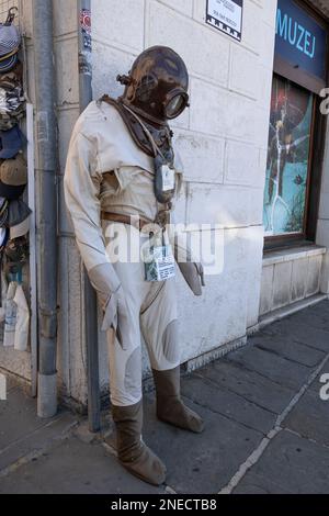 Alter Tiefseetaucheranzug mit Schutzhelm (Kupfermütze) und Spendenbox auf dem Bürgersteig der slowenischen Küstenstadt Piran. Stockfoto