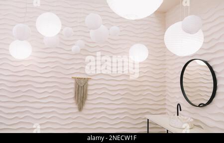 Moderne Einrichtung mit stilvollem Rundspiegel an beigefarbenen Wänden in einem gemütlichen Badezimmer, Kopierbereich, eleganten Accessoires in stilvollem Wohnbereich Stockfoto