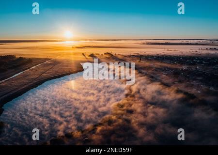 Der wunderschöne Nebel des Sees kommt am Herbstmorgen bei Sonnenaufgang in die Felder Stockfoto