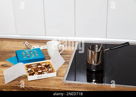 Zürich, Schweiz - Januar 7 2023: Lindt Mini Pralines Box. Öffnen Sie eine kleine Geschenkbox mit Süßigkeiten aus Schweizer Schokolade, die in der Küche zum Kaffee bereit ist. Luxuriöse Auswahl an Milch, dunklen und weißen Süßigkeiten. Stockfoto