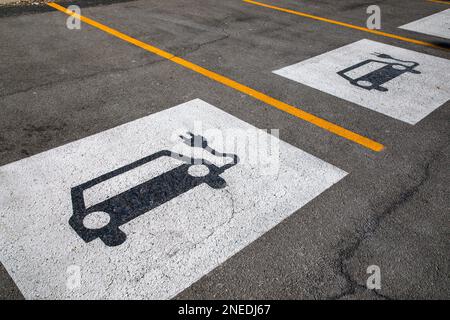 Parkplatzschild für Elektrofahrzeuge auf dem Bürgersteig. Stockfoto