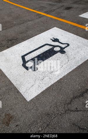 Parkplatzschild für Elektrofahrzeuge auf dem Bürgersteig. Stockfoto
