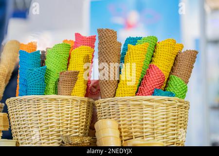 Leere Eiskegel in verschiedenen Farben für verschiedene Geschmacksrichtungen der Speiseeis-Nahaufnahme. Echte Szene in der Eisdiele Stockfoto