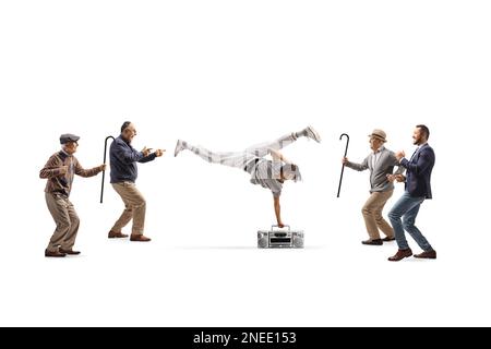 Ein afroamerikanischer Typ, der Handstand mit einer Boombox aufführt und eine Gruppe älterer Männer, die isoliert auf weißem Hintergrund herumtanzen Stockfoto