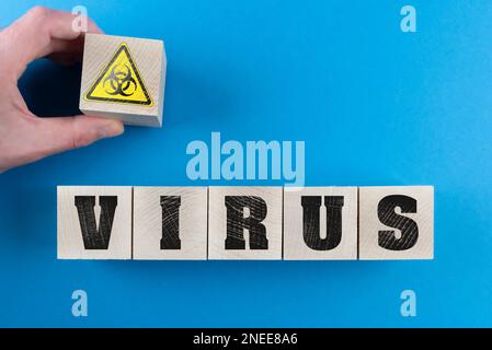Word VIRUS und Biohazard Symbol auf Holzwürfeln, Corona Virus Kovid-19 Ausbruch Warnkonzept Stockfoto