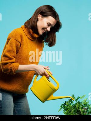 Frau mit mittlerer Schussaufnahme und Gießkannne Stockfoto