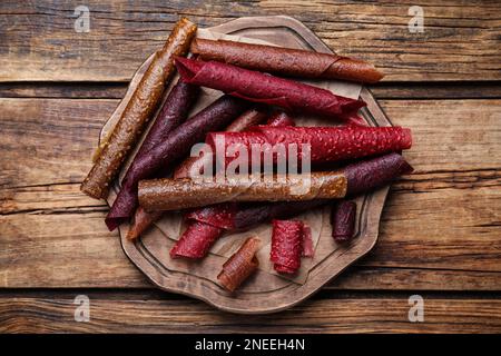 Köstliche Fruchtlederrollen auf einem Holztisch, Draufsicht Stockfoto