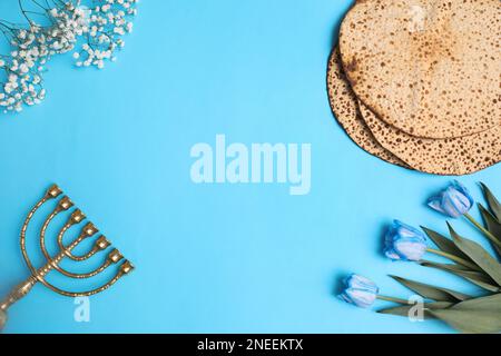 Flache Lay-Komposition mit Matzen auf hellblauem Hintergrund, Platz für Text. Pessach-Feier Stockfoto